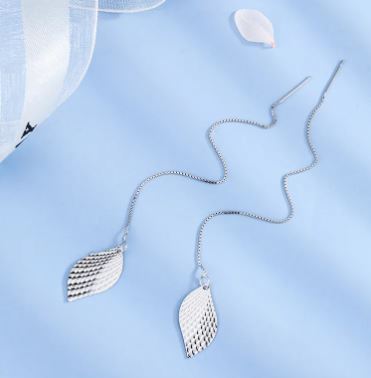 Close-up of elegant nature's leaf charm earrings with intricate tree leaf design hanging gracefully