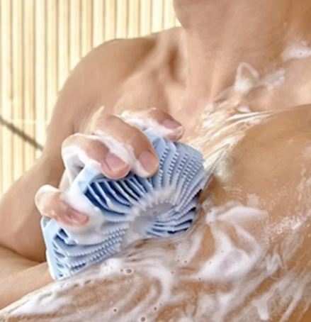 Silicone skin exfoliating brush with soft flexible bristles and non-slip handle for gentle body cleansing and massage